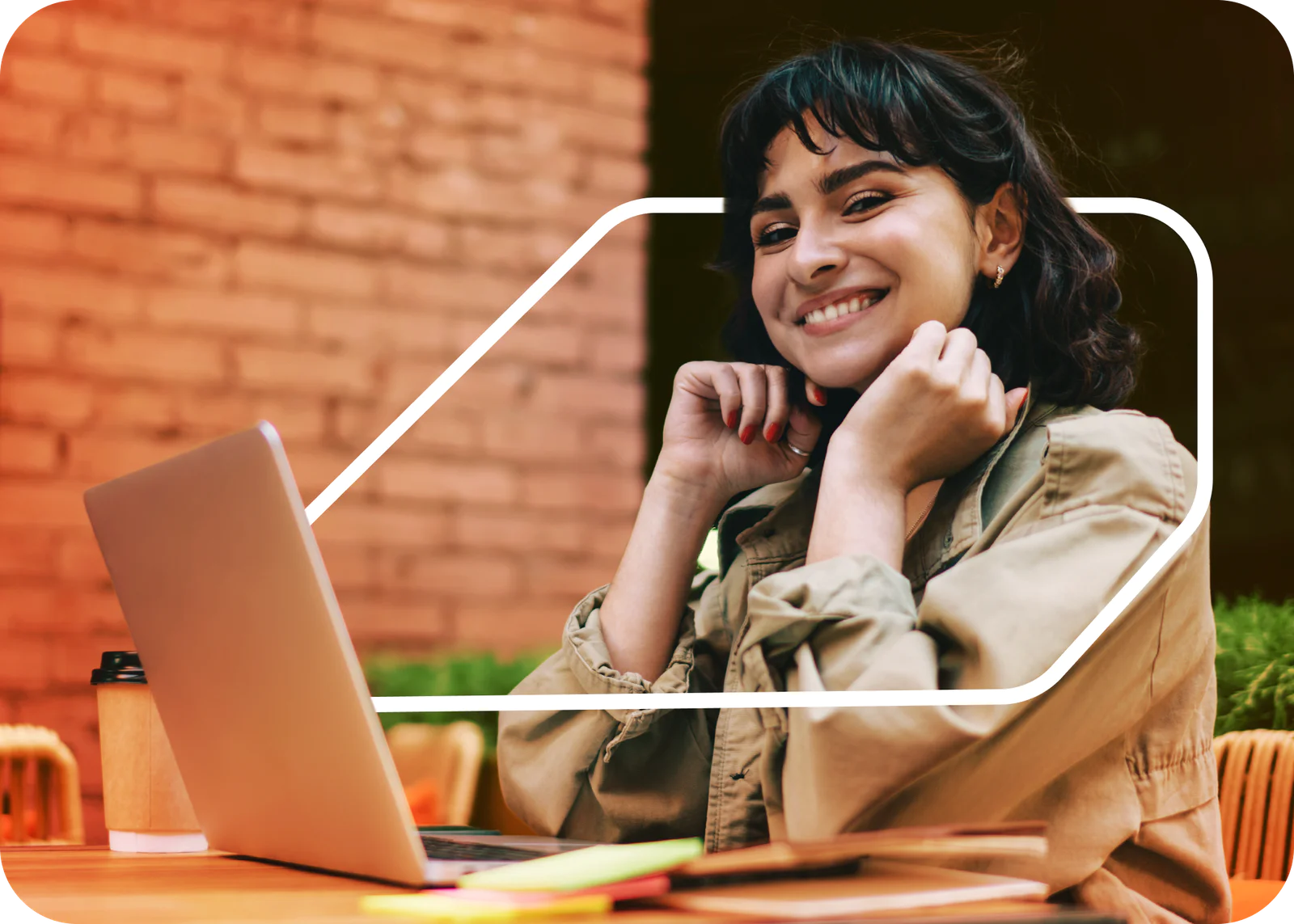 Woman smiling, talking on phone, and writing in notebook Woman smiling, talking on phone, and writing in notebook